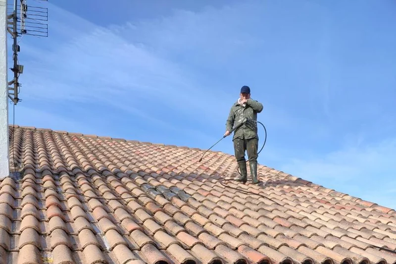 Artisan couvreur au travail sur une toiture du Gard